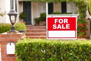 "For sale" sign in front of house