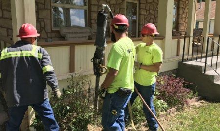 A Ram Jack worker injecting a grout mixture into the soil.