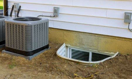  Close-up of an egress window installation, showcasing the window well and proper drainage.