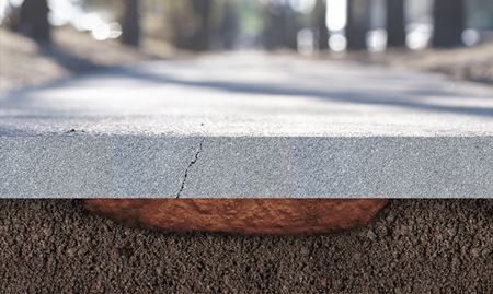 A cross-section view of a sunken concrete slab showing why cracks appear in the foundation's surface