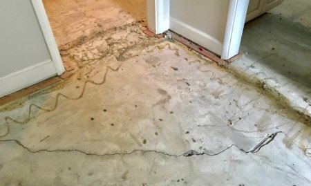 A cracked and uneven concrete slab before repair.