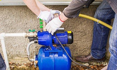 A sump pump installed in a basement or crawl space with a drainage system connected.